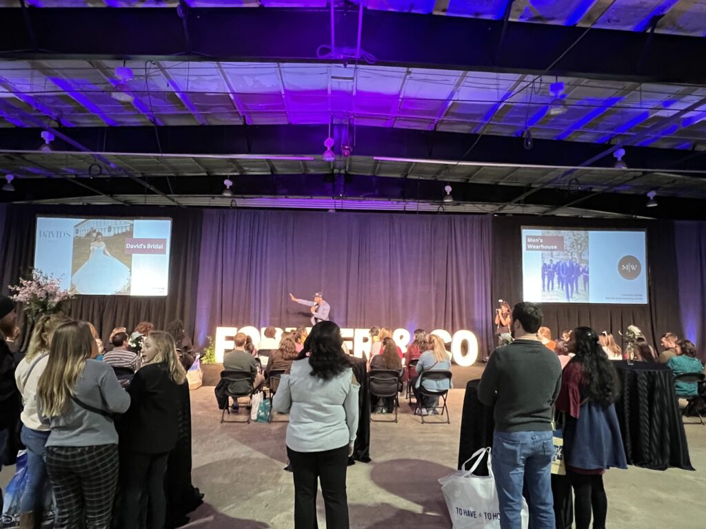Wedding Show stage with black velour drape and rear projected dual screen with event lighting.