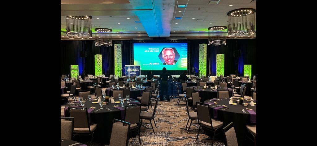 Single Screen event stage with scenic towers and lighting for The Auto Intel Summit